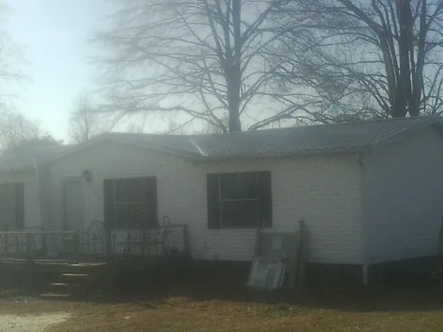 New metal roof on a white painted brick home on a foggy morning in Germantown